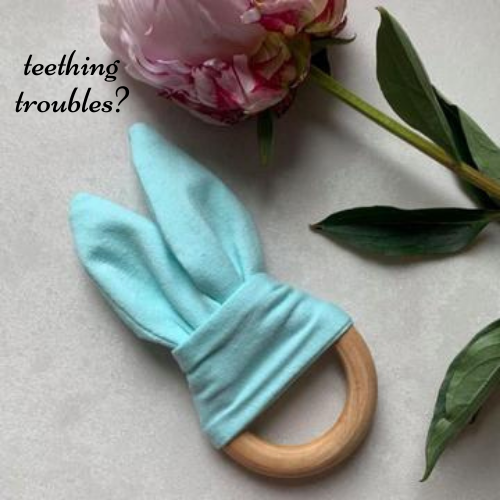 Mint green cotton crinkle bunny ear babies teething ring attached to a natural beechwood ring.
