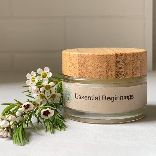 A bamboo and glass re-useable jar showing essential beginnings logo, with a multipurpose balm for adults, babies and children inside.