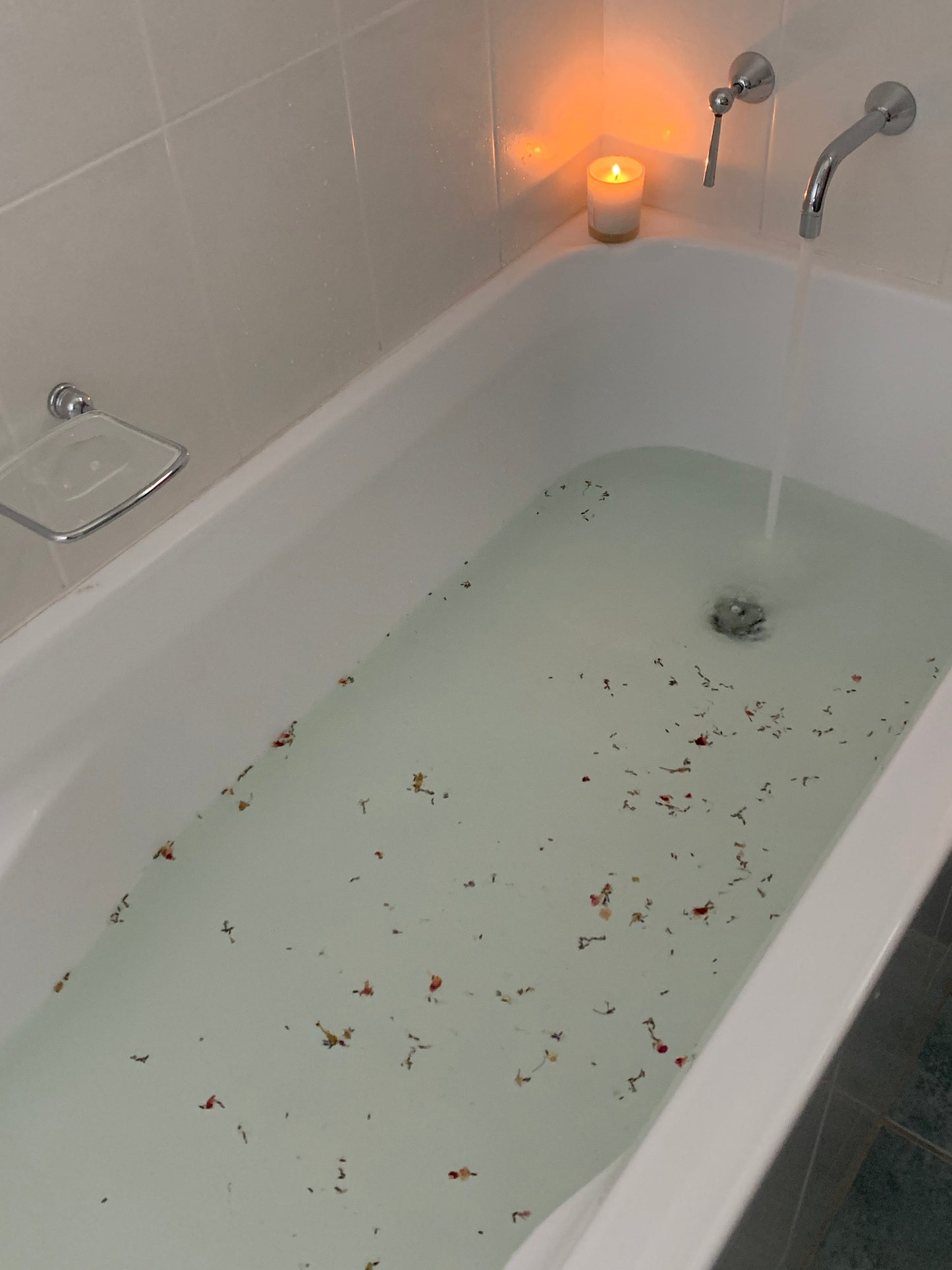Bath being filled with water with "relax" bath salts in the bath.